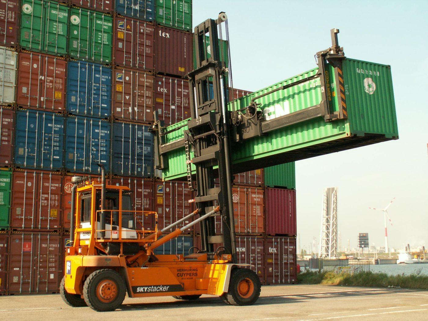 Trade Mar stuffing team, empty-container handler lifting a unit in the customs yard